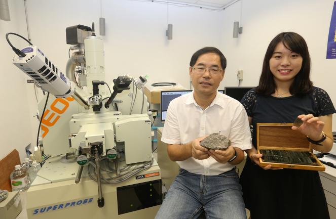 Miss Jessie Kwan Long-ching (left), under the supervision of Professor Zhao Guochun, conducts her research with the aid of the Electron Probe Micro-Analyzer (EPMA).